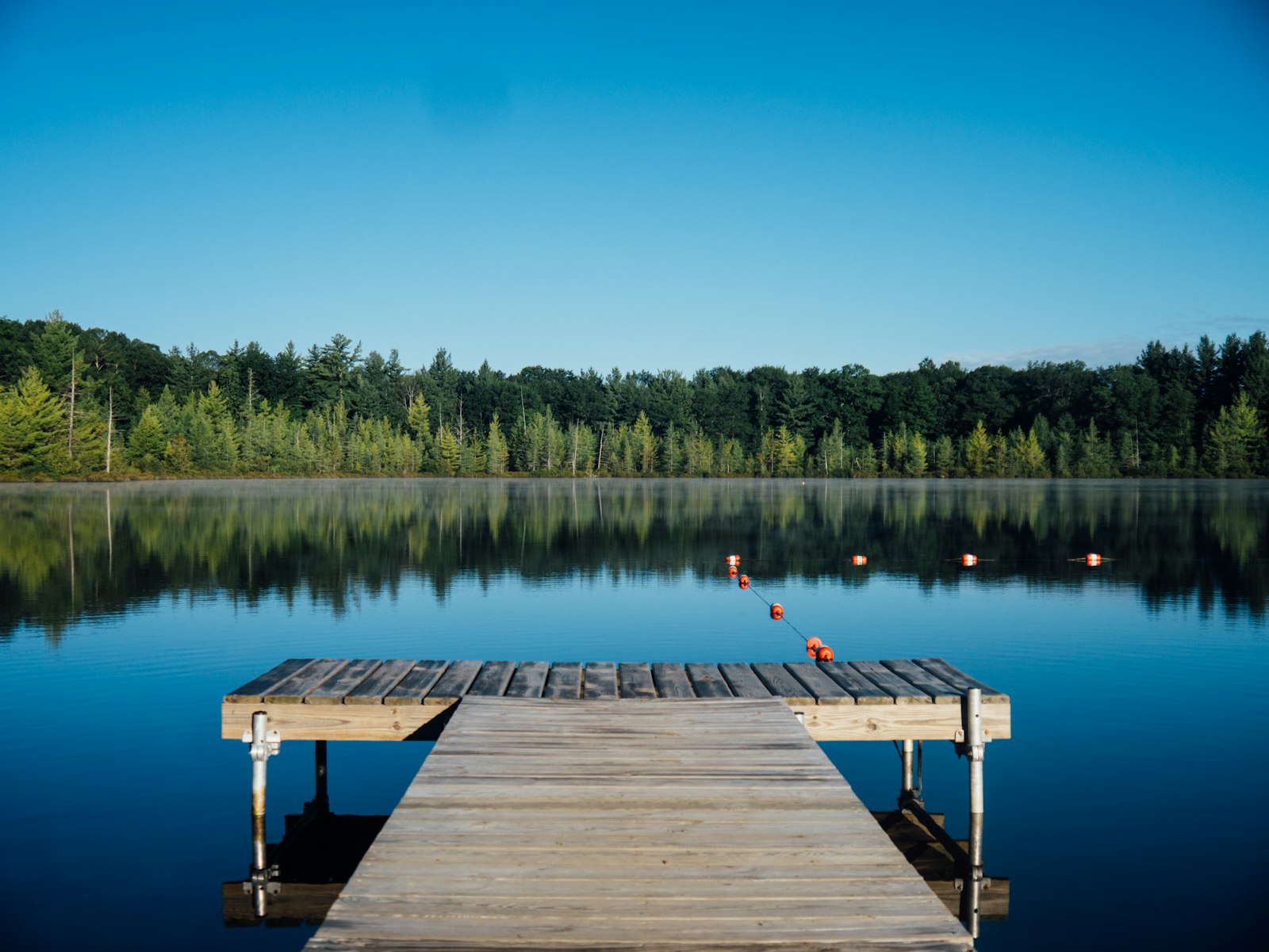 Still water stretching to a distant shore under a quiet sky
